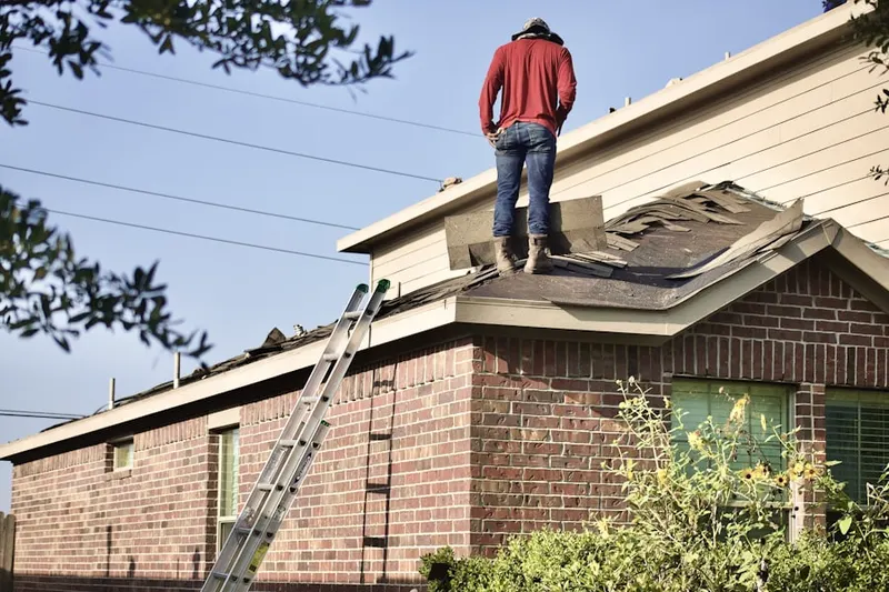 Professional roofer working on a residential roof in Kenyon
